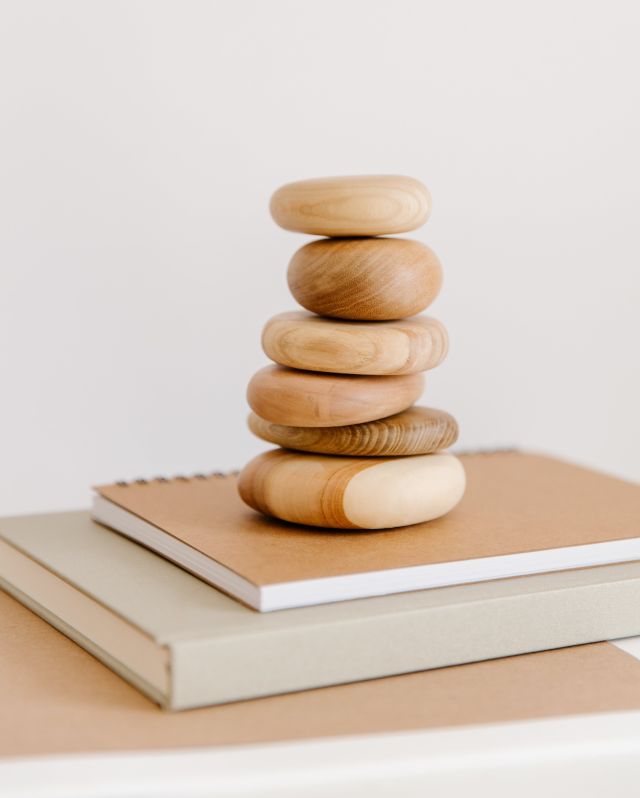 Stack of Round Polished Wood Chunks and Beige Notebooks